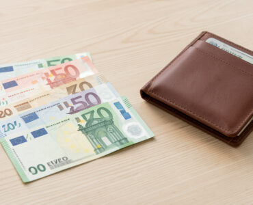 Billets en euros de différentes coupures disposés sur une table claire à côté d’un portefeuille ouvert, dans une ambiance réaliste et pédagogique.