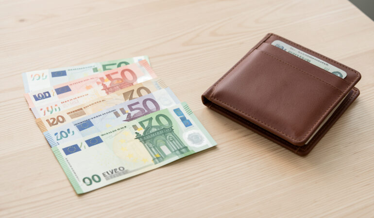 Billets en euros de différentes coupures disposés sur une table claire à côté d’un portefeuille ouvert, dans une ambiance réaliste et pédagogique.
